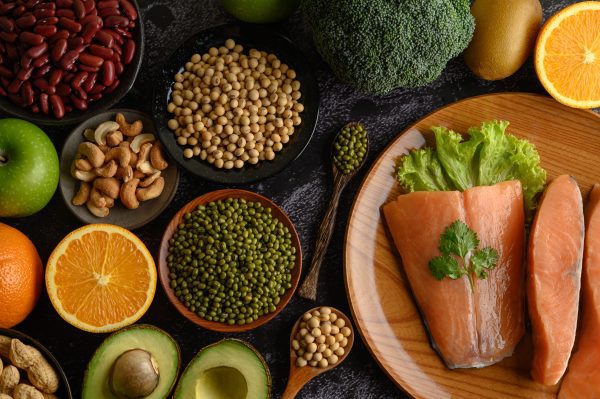 Variedade de alimentos saudáveis para a pele, incluindo frutas, verduras e peixes, ilustrando uma dieta balanceada.