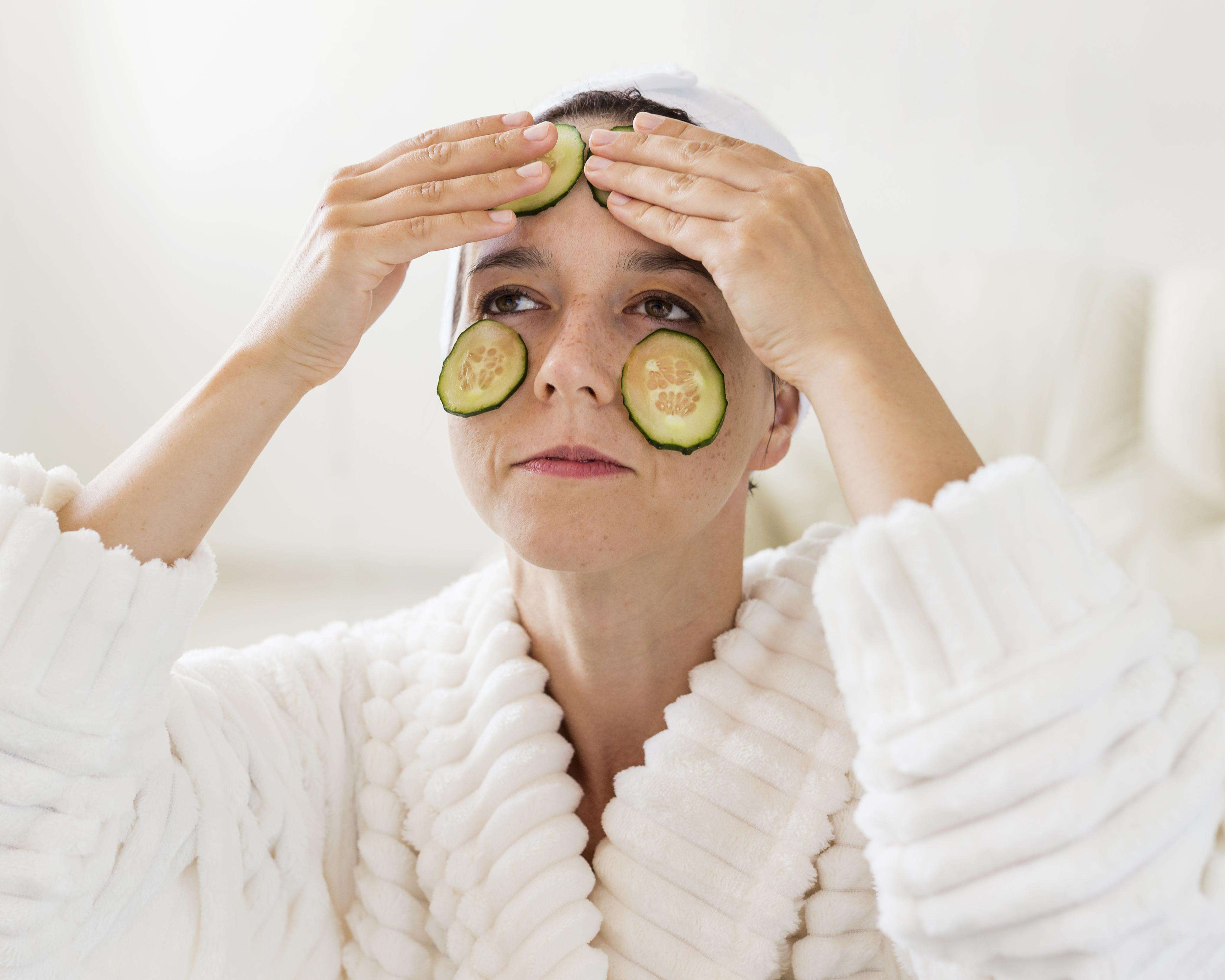 Imagem mostrando ingredientes naturais usados em remédios caseiros para tratar olheiras, como pepino e chá de camomila.