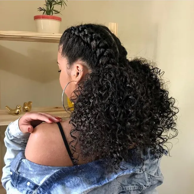 Trança embutida elegante em cabelo cacheado, destacando a habilidade de tecer os cachos em um penteado intricado e sofisticado.