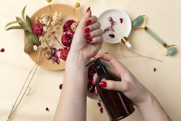 Imagem mostrando mãos com unhas saudáveis e produtos naturais usados para fortalecimento das unhas.