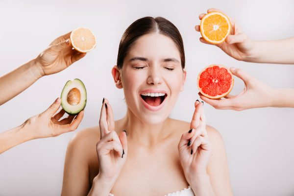 Imagem de alimentos ricos em vitaminas essenciais dispostos artisticamente, destacando sua importância para a saúde da pele.